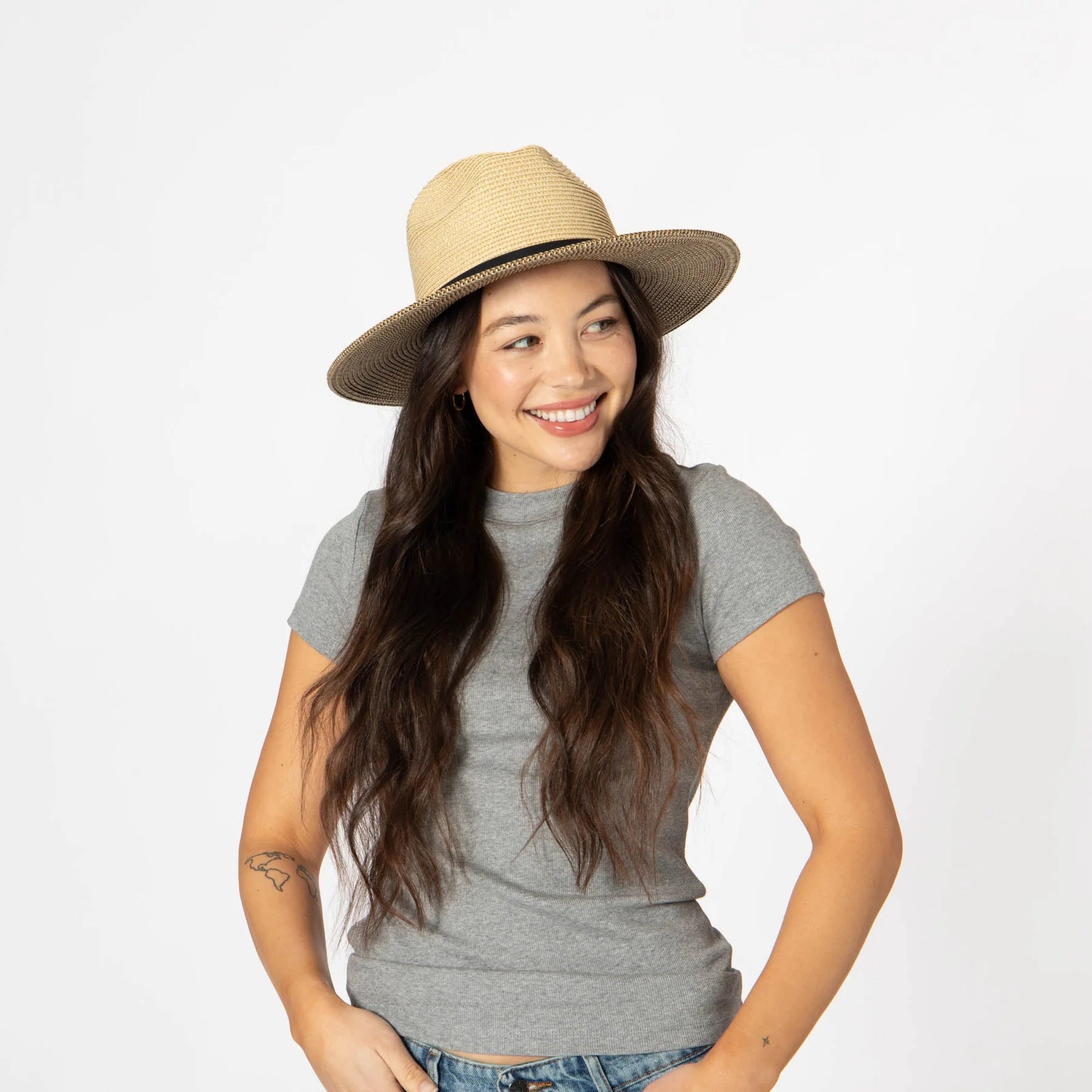Woman wearing a beige hat and gray shirt on a white background